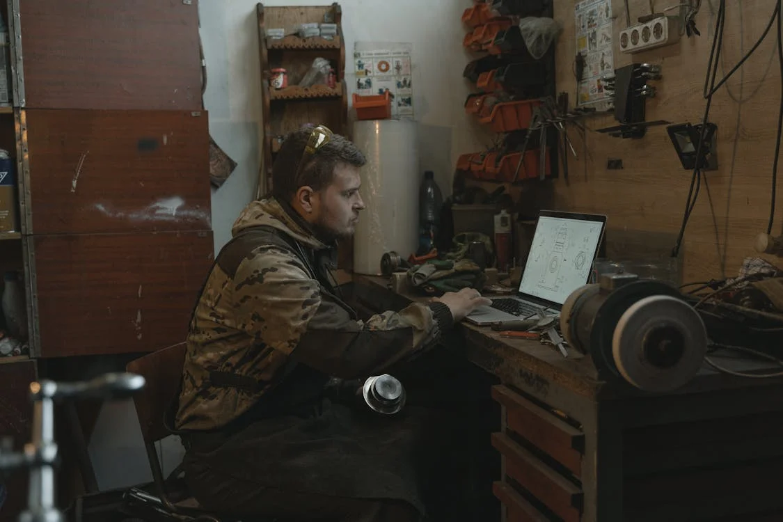 mechanic using laptop in garage