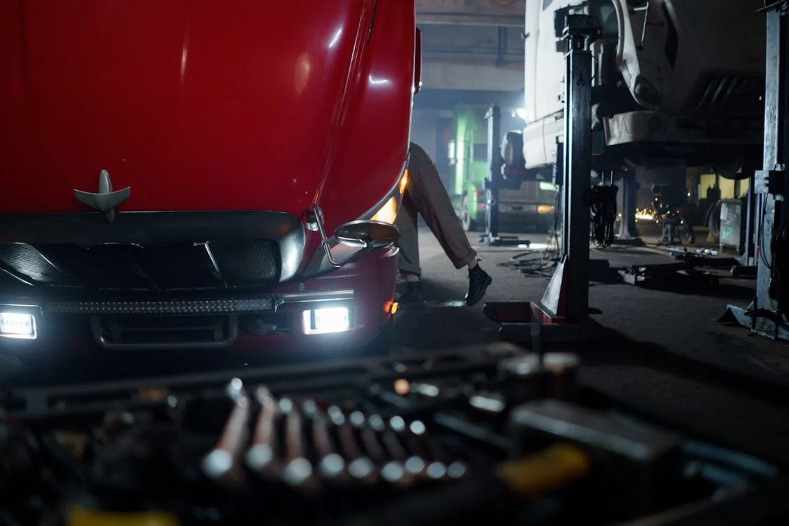 mechanic opening hood of red semi truck