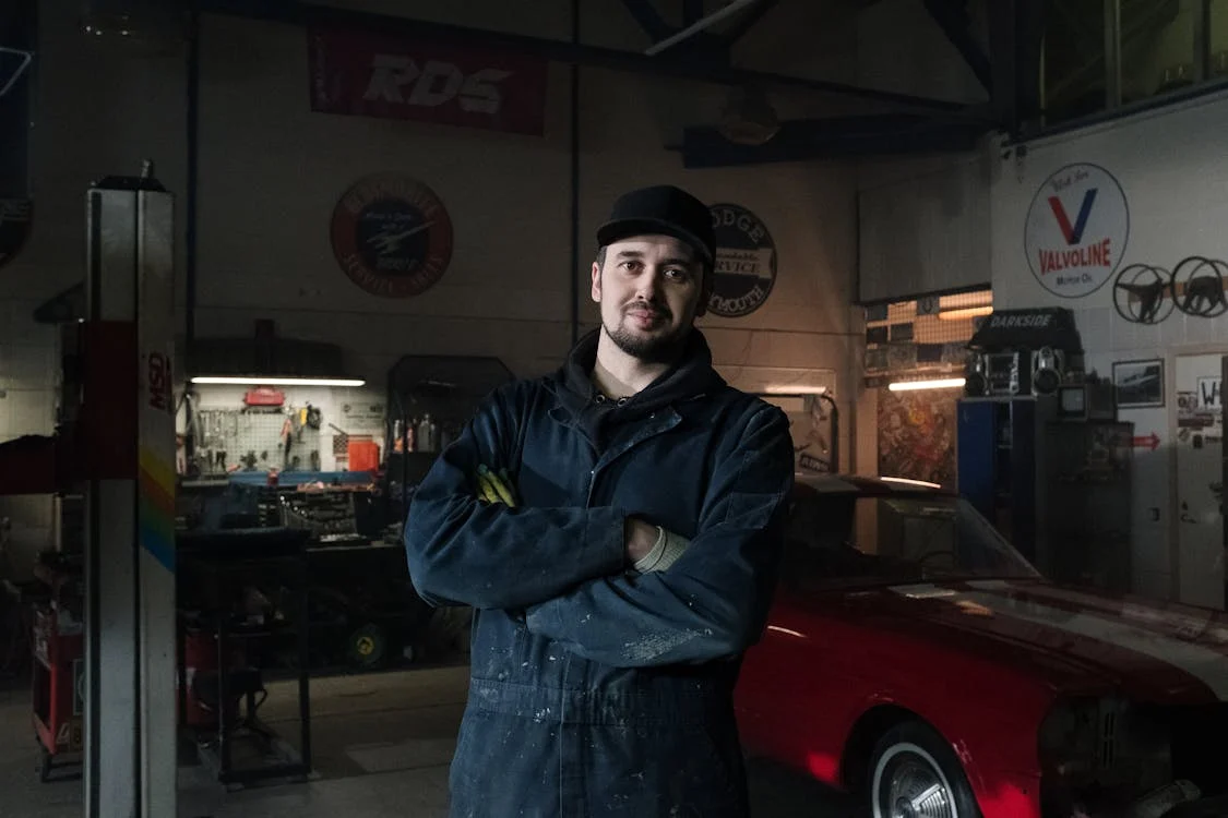 mechanic standing in garage with arms crossed