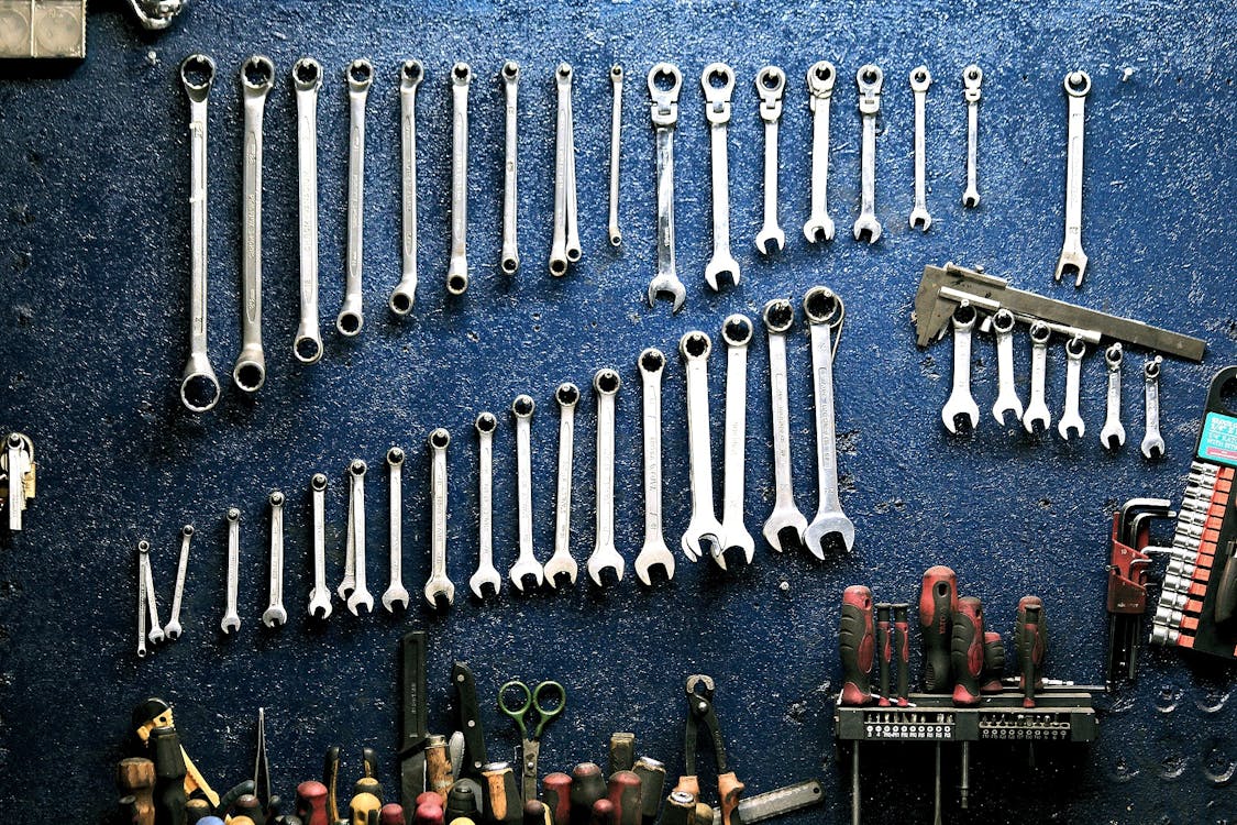 set of wrenches hanging on blue wall