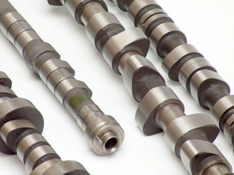 Metal camshafts on a white surface